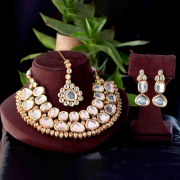 Kundan-style necklace set with matching earrings and maang tikka displayed together